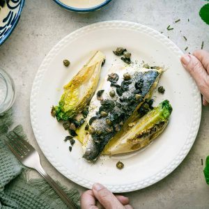 Oven-baked wild sea bass with mustard sauce and sautéed baby gem lettuce